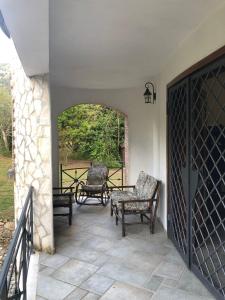 un patio con sillas, una mesa y una puerta en B&B Villa Torri Petrose en Pontelatone