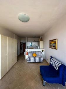 un soggiorno con una sedia blu e un divano di Casa Pinolo Monolocale Vista Mare a Follonica Altre 15 foto