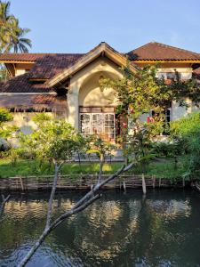 una casa con un estanque delante de ella en Les Rizieres Lombok - Tetebatu, en Tetebatu