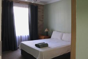 a bedroom with a white bed with a window at Launa La Crete 78 in Margate +9 photos