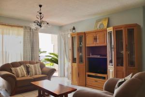 ein Wohnzimmer mit einem Sofa und einem TV in der Unterkunft Launa La Crete 78 in Margate