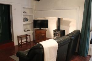 un salon avec un canapé en cuir et une cheminée dans l'établissement Casa das Correias, à Évora Monte