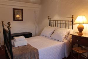 - une chambre avec un lit et une table avec une lampe dans l'établissement Casa das Correias, à Évora Monte
