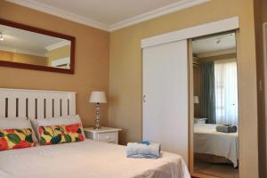Schlafzimmer mit einem Bett und einem Spiegel in der Unterkunft Launa La Crete 78 in Margate