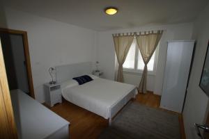 a bedroom with a white bed and a window at Chalet Alpina in Bovec