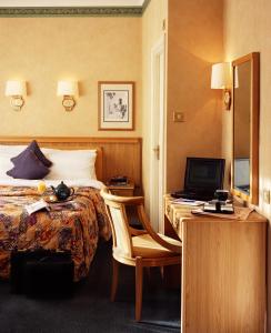 倫敦的住宿－博嘉亞樂園倫敦酒店，酒店客房配有一张床和一张带电脑的书桌