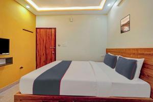 a bedroom with a large bed and a television at Collection O Sri Sapthagiri Near Phoenix Marketcity in Bangalore
