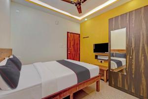 a bedroom with a bed and a television in it at Collection O Sri Sapthagiri Near Phoenix Marketcity in Bangalore