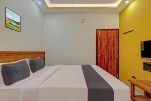 a bedroom with a large bed and a wooden door at Collection O Sri Sapthagiri Near Phoenix Marketcity in Bangalore