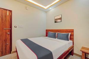 a bedroom with a large bed with blue pillows at Collection O Sri Sapthagiri Near Phoenix Marketcity in Bangalore