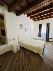 a bedroom with two beds and a wooden floor at B&B Cinisi Vacanze 2.0 in Cinisi