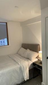 マンチェスターにある2 Bedroom Apartment in Salford Manchesterのベッドルーム1室(ベッド1台、ナイトスタンド、窓付)
