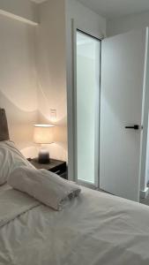 a bedroom with a bed with a lamp and a glass door at 2 Bedroom Maisonette in Salford in Manchester