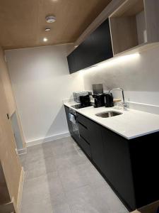 a kitchen with a sink and a counter top at 2 Bedroom Maisonette in Salford in Manchester