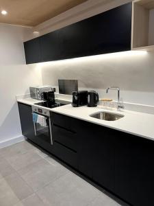 a kitchen with a sink and a counter top at 2 Bedroom Maisonette in Salford in Manchester