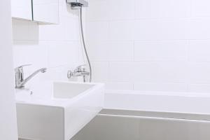 a white bathroom with a sink and a bath tub at Kalamaja Park Apartment fast net 150 G, bath in Tallinn +29 photos