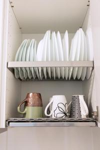 a shelf in a kitchen filled with plates and vases at Kalamaja Park Apartment fast net 150 G, bath in Tallinn