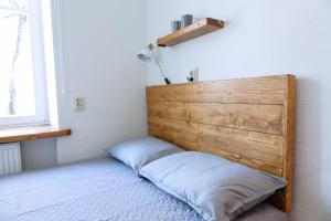 a bed with a wooden headboard in a room at Kalamaja Park Apartment fast net 150 G, bath in Tallinn