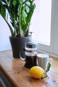 a coffee maker and a lemon on a wooden table at Kalamaja Park Apartment fast net 150 G, bath in Tallinn