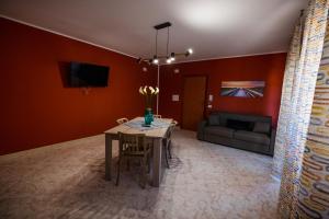 ein Esszimmer mit einem Tisch und einem Sofa in der Unterkunft Sole & Luna Apartment in Marsala