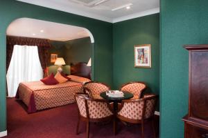 a bedroom with a bed and a table and a mirror at Berjaya Eden Park London Hotel in London