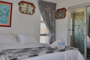 a bedroom with a bed and a glass door at laguna la Crete 98 in Uvongo Beach