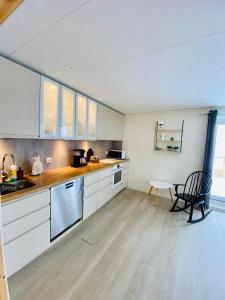 a kitchen with white cabinets and a table and a chair at Fjordgård Mountain Aurora View in Fjordgård