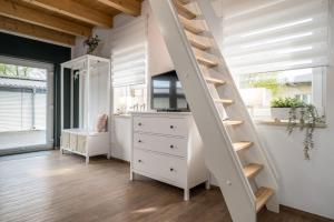een witte trap in een kamer met een dressoir bij Ferienwohnung Zwischen den Seen in Vietzen