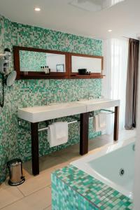 波多博羅的住宿－Le Golfe，浴室配有盥洗盆和浴缸。