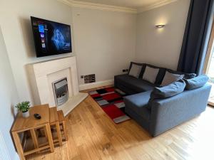 a living room with a couch and a fireplace at 2 Castle Hume Court Holiday House in Enniskillen