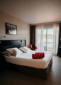 a bedroom with a large bed with a red towel on it at Le Golfe in Porto Pollo