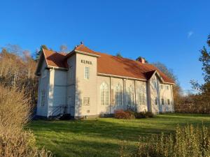 une maison ancienne avec un toit rouge sur une pelouse dans l'établissement Betel Hem, à Hällefors