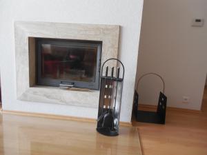 a fireplace with two black sculptures in front of it at Apartman MARLEA in Donovaly
