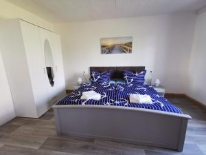 a bedroom with a bed with blue and white stripes at Ferienwohnung Am Stadtrand Garz Rügen in Garz-Rügen