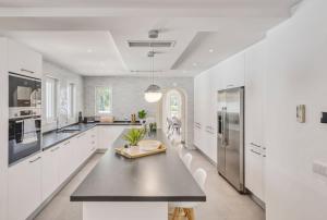 a kitchen with white cabinets and a black counter top at Villa Beleza in Portimão