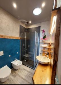 LucinascoにあるIL NIDO TRA GLI ULIVIのバスルーム(洗面台2台、ガラス張りのシャワー付)