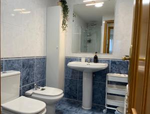 a bathroom with a toilet and a sink and a mirror at BierzINN apartamento in Ponferrada