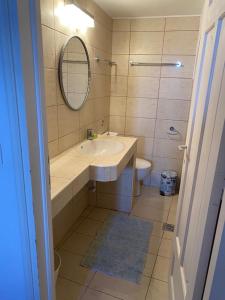 a bathroom with a sink and a mirror and a toilet at The Captain's House in Skiathos