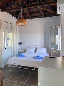 a bedroom with a white bed with blue towels on it at The Captain's House in Skiathos