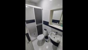 ein Badezimmer mit Toilette, Waschbecken und Spiegel in der Unterkunft Cozy room Bm-10 near the sea with air conditioning and WIFI in Cartagena de Indias