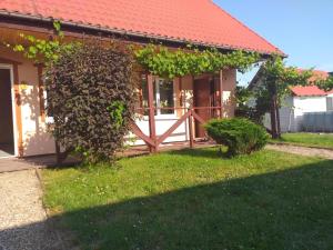 ein Haus mit einem Holztor im Hof in der Unterkunft Przestronne domki Sztutowo in Sztutowo