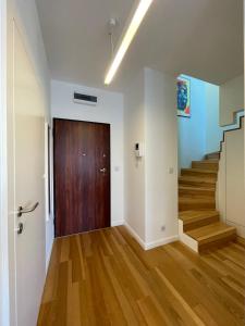 an empty hallway with a wooden door and stairs at Elegant Apart-800m Main Square-Parking and lift in Wrocław