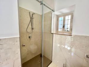 een douche met een glazen deur in de badkamer bij LEI LUXURY APARTMENT in Maiori