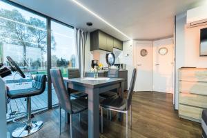 a kitchen and dining room with a table and chairs at Domek na wodzie Topiko Czarter przy Hotelu Ognisty Ptak in Ogonki