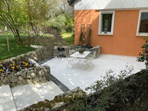 a patio with a table and a stone wall at Villa Magnolia in Arcugnano