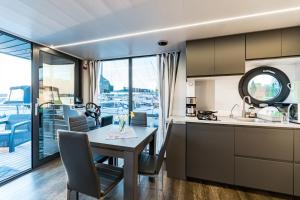 a kitchen and dining room with a table and a view of a boat at Domek na wodzie Topiko Czarter przy Hotelu Ognisty Ptak in Ogonki