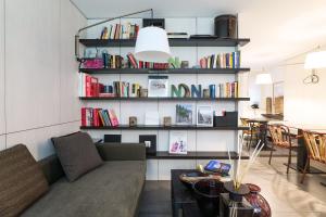 a living room with a couch and a book shelf with books at Nen&egrave;-Il Vicolo Apartments and Rooms in Bellagio