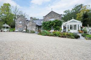 une grande maison en pierre avec une allée. dans l'établissement Luxury Country House Glendalough Wicklow, à Laragh