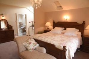 a bedroom with a large bed and a chair at Luxury Country House Glendalough Wicklow in Laragh