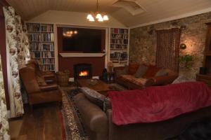 a living room with leather couches and a fireplace at Luxury Country House Glendalough Wicklow in Laragh